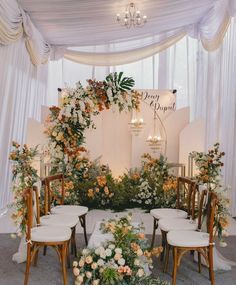 a wedding ceremony setup with white chairs and flowers