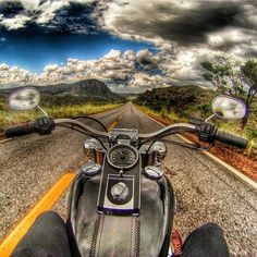 a person riding on the back of a motorcycle down a road