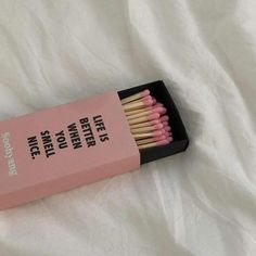 a pink box filled with matches on top of a white sheet