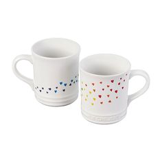 two coffee mugs with hearts painted on them