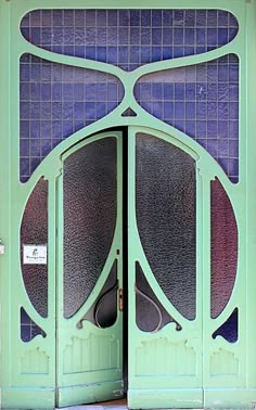 an open green door with blue tiles on it