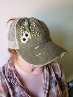 a woman wearing a hat with flowers on it's brimmed visor