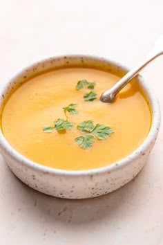 a white bowl filled with soup and garnished with cilantro