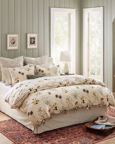 a large bed sitting in a bedroom on top of a rug next to a window