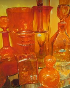 an assortment of orange glass vases and bottles