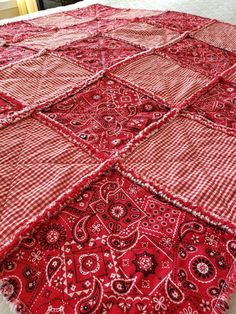 a red and white quilt on top of a bed