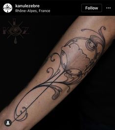 a person with a tattoo on their arm that has an image of a flower in it