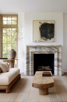 a living room filled with furniture and a fire place in front of a painting on the wall