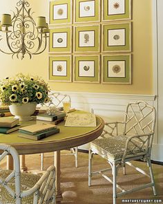 a dining room table with chairs and pictures on the wall above it, along with a potted sunflower