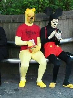 two people in costumes sitting on a bench