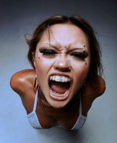 a woman with her mouth open and piercings on