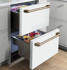 an open drawer in the middle of a kitchen with various food items on it, including fruit and vegetables