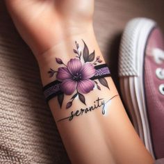 a woman's wrist tattoo with flowers and the word serenity written on it