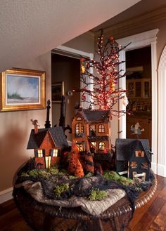 a christmas tree is in the middle of a table with houses and trees on it