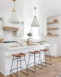 a kitchen with white cabinets and wooden stools