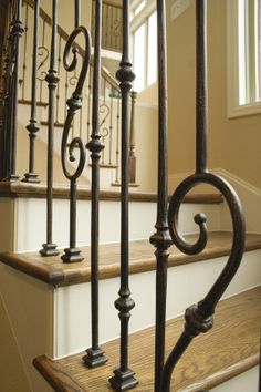 an iron stair railing with wooden steps in a home