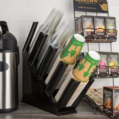 there are many cups and coffee mugs in this holder on the counter next to each other