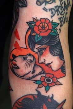 a woman's arm with tattoos on it and a cat in the middle of her arm