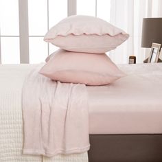 pillows and blankets sit on top of a bed