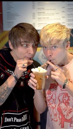 two young men are eating ice cream together