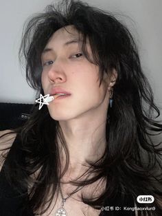 a woman with long black hair has a fake star on her nose and is wearing a necklace