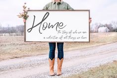 a man holding up a sign that says family is everything on the side of a dirt road