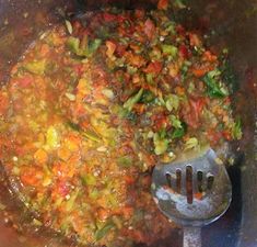 a pot filled with lots of food and a spoon on top of the pot full of it