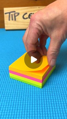 a person placing a piece of paper on top of a blue mat