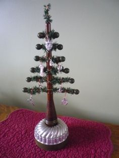 a small christmas tree on a table with pink carpeting and white walls in the background