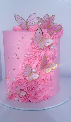 a pink cake with gold butterflies on top