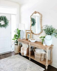 a wooden table topped with potted plants next to a mirror