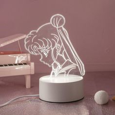 a lamp that is sitting on top of a table next to a piano and ball