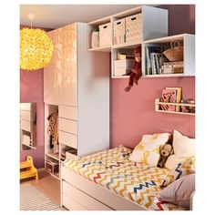 a child's bedroom with pink walls, white furniture and toys on the shelves