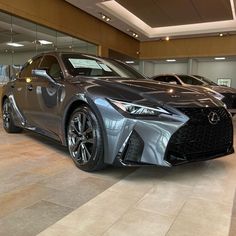 two gray cars are parked in a showroom