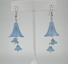 This is a pair of silver toned fish hook style earrings.  They feature a light blue acrylic trumpet flower with two flowers with pearl centers hanging below.  The drop length is 2.5 feet inches. Affordable Blue Flower Charm Earrings, Prom Vibes, Handmade Earings, Light Blue Earrings, Lucite Flower Earrings, Trumpet Flower, Two Flowers, Jewelry Making Earrings, Ear Ring