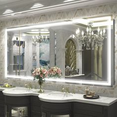 a bathroom with two sinks and a large mirror over it's sink area in front of a chandelier