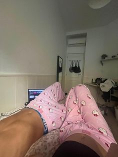 a person laying on top of a bed wearing pink pajamas