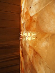 the sauna & flame logo is displayed in front of a wall made out of rocks