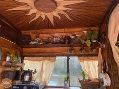 the inside of a small wooden cabin with pots and pans on the stove top