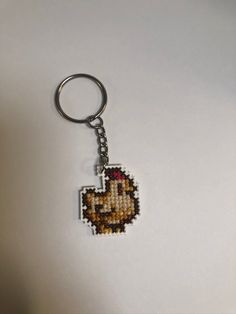 a keychain with a pixellated image of a chicken on it's side