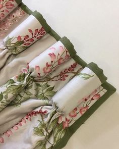 three folded towels with pink flowers on them