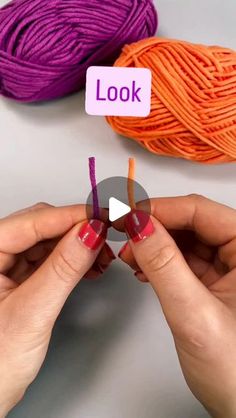 two hands holding yarn with the words look on them and an orange ball of yarn in the background