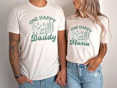 a man and woman standing next to each other wearing shirts that say one happy daddy