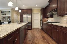 a kitchen with wooden floors and brown cabinets