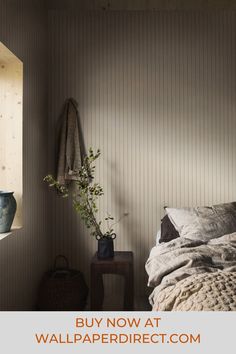 a bedroom with striped walls and a plant in the corner