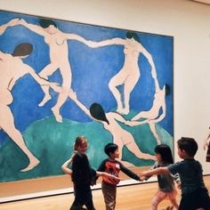 four children are standing in front of a large painting on the wall and playing with each other