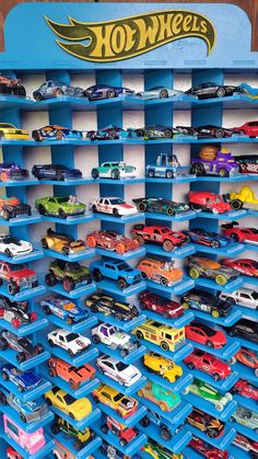 there are many toy cars on display in the store's blue shelve