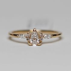 a yellow gold engagement ring with three pear shaped diamonds