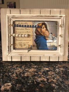 a wooden frame with an image of a woman holding a baby