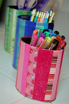 there are many pens and pencils in the cup on the table next to each other